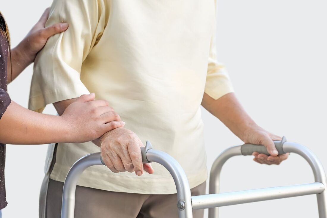 Live-In Caregiver holding Care Recipient on a Walking Frame